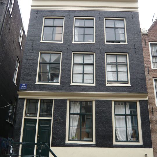 Huis met gevel onder rechte lijst waarboven een stenen punttopje uitsteekt