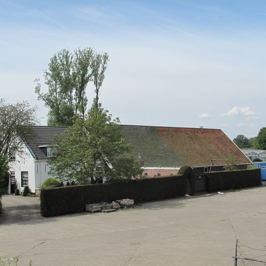 Bakstenen woonhuis, gepleisterd aan de plint en rond de voordeur. Aangebouwde schuur met pannen zadeldak en houten topgevellijst. Zomerhuis