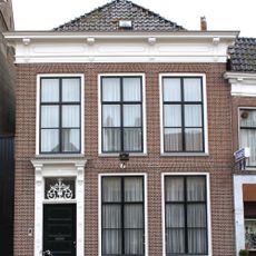 Woonhuis met verdieping en rechte rechte kroonlijst met consoles en versierd bovenlicht